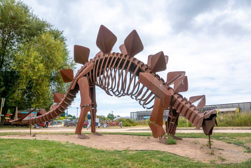 Sculpture de dinosaure en métal devant le Paleospace